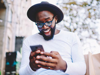 Ein Kunde schaut erfreut auf sein Smartphone